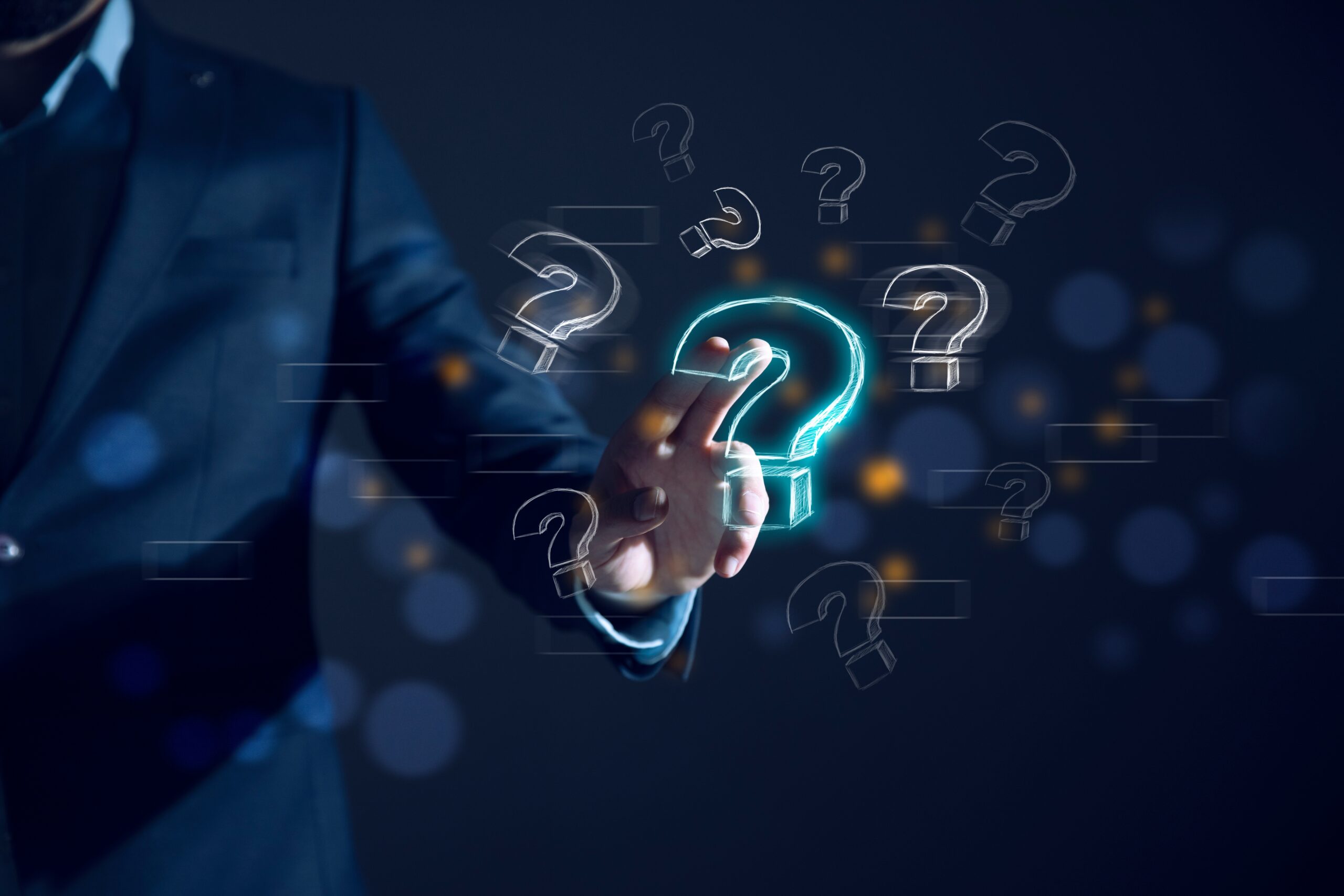 Businessman in a suit interacting with a holographic display of question marks, highlighting one glowing question mark
